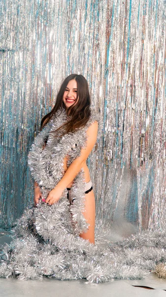 Stüdyoda poz veren parlak noel süsleriyle güzel seksi kadın, tatil konsepti.   