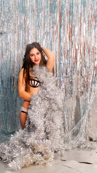 Stüdyoda poz veren parlak noel süsleriyle güzel seksi kadın, tatil konsepti.   