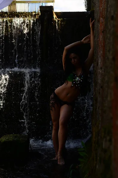 Genç esmer model bir şelale karşı poz