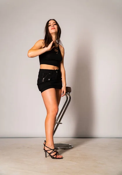 Retrato de la mujer joven desconcertada con ropa ligera mirando a un lado cubriendo la nariz con la mano aislada sobre fondo de pared blanca en estudio. Gente sincera emociones, concepto de estilo de vida. Almacenamiento del espacio de copia —  Fotos de Stock