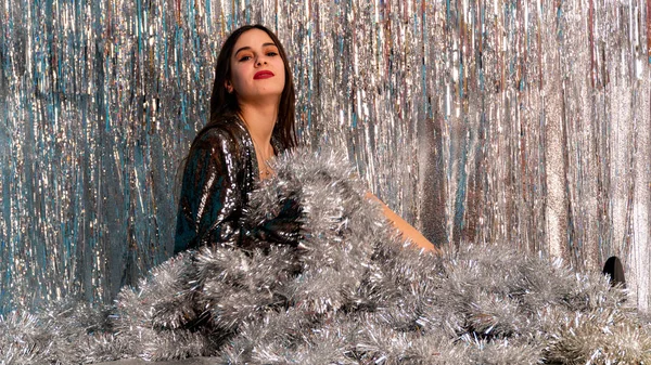 Stüdyoda poz veren parlak noel süsleriyle güzel seksi kadın, tatil konsepti.   