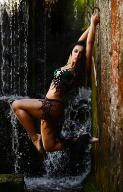 Genç esmer model bir şelale karşı poz