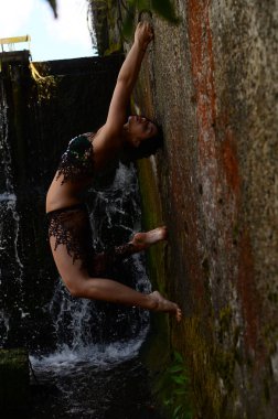 Genç esmer model bir şelale karşı poz