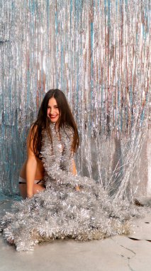 Stüdyoda poz veren parlak noel süsleriyle güzel seksi kadın, tatil konsepti.   