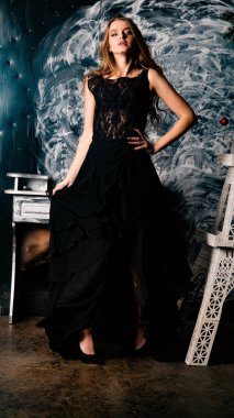 Stüdyoda dantel elbiseyle poz veren genç ve güzel bayan.  