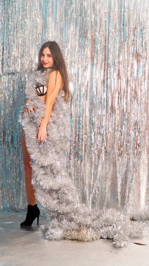 Stüdyoda poz veren parlak noel süsleriyle güzel seksi kadın, tatil konsepti.   