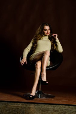 Parlak elbiseli çekici kadın siyah arka planda poz veriyor. 