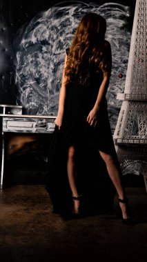 Stüdyoda poz veren narin siyah elbiseli kadın.  