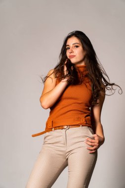 Güzel esmer model, karanlık odada poz veriyor. 