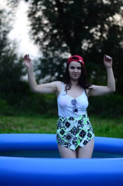 Gün batımında, havuzda ıslak güzel bir kız bedeni..