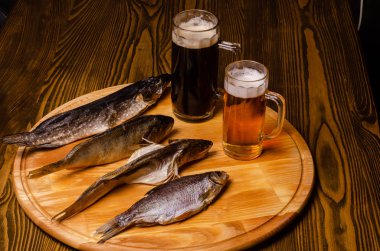 Bira bardağı, arka planda kurutulmuş balık, ahşap bir masada, kırsal bir tarzda..