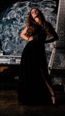 Stüdyoda poz veren narin siyah elbiseli kadın.  