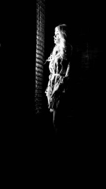 Güzel, şık, sarışın, makyajlı, siyah arka planda saç kesimi olan bir kadın.  