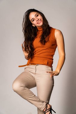 Güzel esmer model, karanlık odada poz veriyor. 