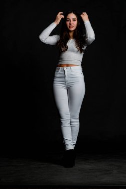 Saçları topuz şeklinde olan genç bayan kollarını kavuşturup yukarı bakıyor. Gri elbiseli, ısıran dudakları olan, arzularını düşünen kaprisli kadın manken. Hayal dünyası konsepti