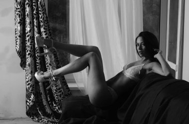 İç çamaşırlarıyla kanepede poz veren sevimli, çekici, çekici bir kızın portresi. 