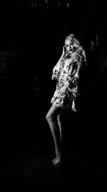 Güzel, şık, sarışın, makyajlı, siyah arka planda saç kesimi olan bir kadın.  