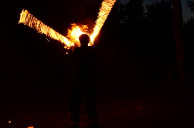 Usta fakir karanlıkta ateş gösterisi sırasında alevlerle gösteri yapıyor..