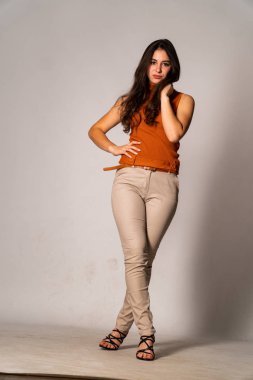 Güzel esmer model, karanlık odada poz veriyor. 