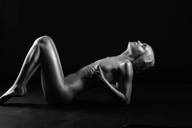 Gümüş rengi vücut boyalı genç atletik kadın.