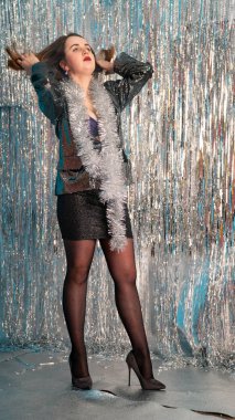 Stüdyoda poz veren parlak noel süsleriyle güzel seksi kadın, tatil konsepti.   