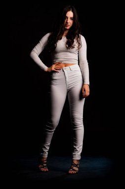 Saçları topuz şeklinde olan genç bayan kollarını kavuşturup yukarı bakıyor. Gri elbiseli, ısıran dudakları olan, arzularını düşünen kaprisli kadın manken. Hayal dünyası konsepti