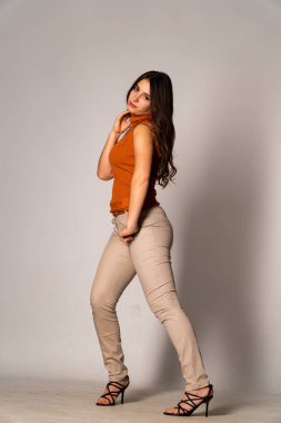 Güzel esmer model, karanlık odada poz veriyor. 