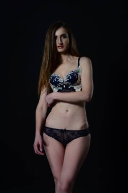 Sarı ceketli, şortlu ve topuklu ayakkabılı zarif bir kadın. Moda stüdyosu çekimi.