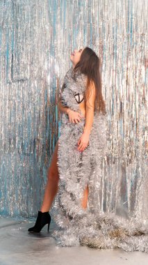 Stüdyoda poz veren parlak noel süsleriyle güzel seksi kadın, tatil konsepti.   