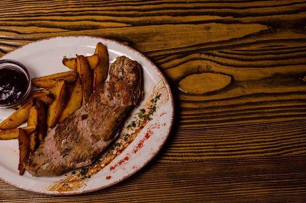 Мясо с картошкой в тарелке для выпечки и сметаной крупным планом на столе. горизонтальный вид сверху — стоковое фото