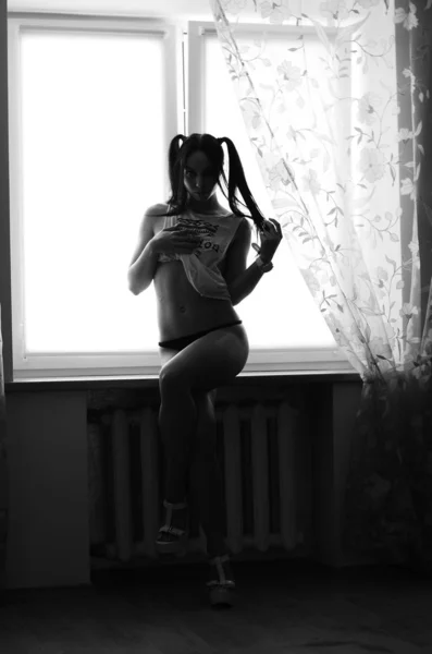 Egy gyönyörű, szexi barna nő áll az ágyneműben. — Stock Fotó