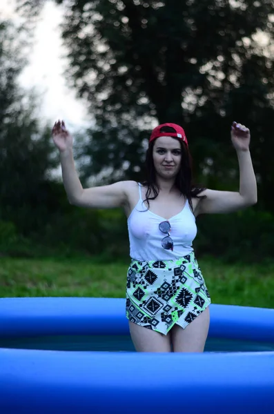 Gün batımında, havuzda ıslak güzel bir kız bedeni..