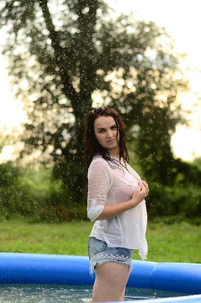 Gün batımında, havuzda ıslak güzel bir kız bedeni.