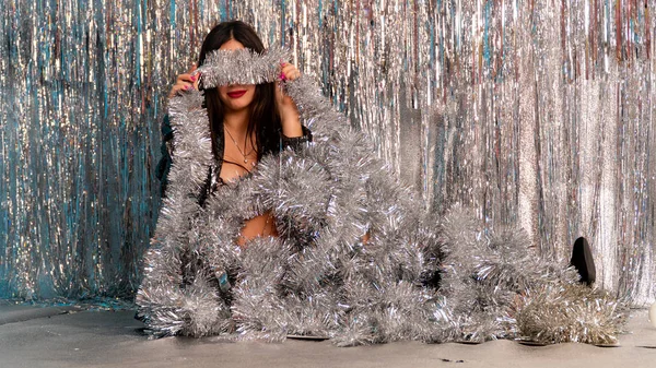 Stüdyoda poz veren parlak noel süsleriyle güzel seksi kadın, tatil konsepti.   