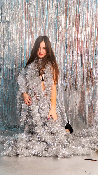 Stüdyoda poz veren parlak noel süsleriyle güzel seksi kadın, tatil konsepti.   