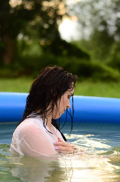 Hermosa chica de tamaño más húmedo en la piscina, al atardecer — Foto de Stock