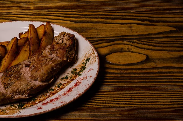 Мясо с картошкой в тарелке для выпечки и сметаной крупным планом на столе. горизонтальный вид сверху — стоковое фото