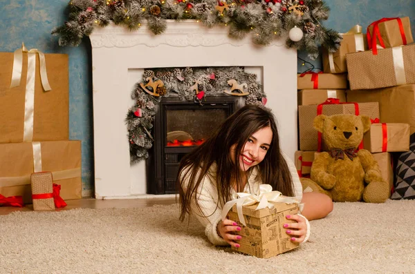 Noel süslemeli stüdyoda şöminenin yanında poz veren çekici esmer kadın.  