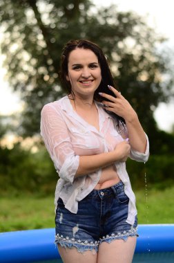 Gün batımında, havuzda ıslak güzel bir kız bedeni..