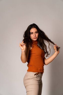 Güzel esmer model, karanlık odada poz veriyor. 