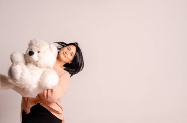 beautiful young woman with teddy bear on white background