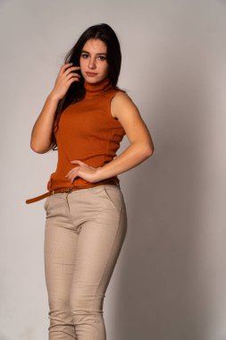 Güzel esmer model, karanlık odada poz veriyor. 