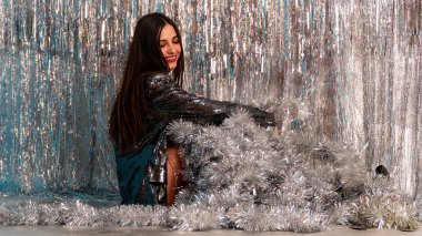 Stüdyoda poz veren parlak noel süsleriyle güzel seksi kadın, tatil konsepti.   