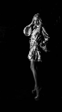 Güzel, şık, sarışın, makyajlı, siyah arka planda saç kesimi olan bir kadın.  