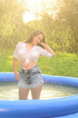 Gün batımında, havuzda ıslak güzel bir kız bedeni..