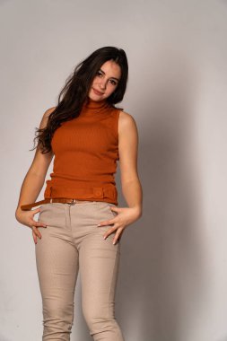 Güzel esmer model, karanlık odada poz veriyor. 