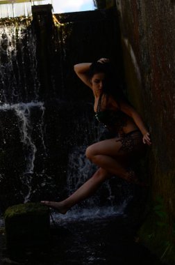 Genç esmer model bir şelale karşı poz