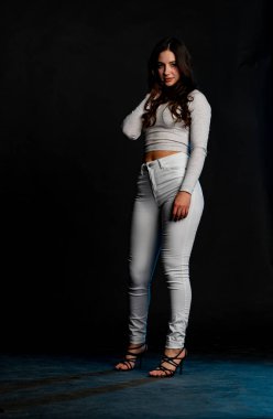 Saçları topuz şeklinde olan genç bayan kollarını kavuşturup yukarı bakıyor. Gri elbiseli, ısıran dudakları olan, arzularını düşünen kaprisli kadın manken. Hayal dünyası konsepti