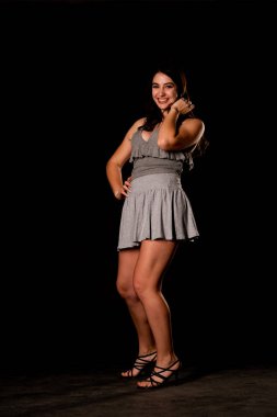 Seksi, güzel, esmer, esmer bir kadın. Kıyafet şortu ve ceket makyajı giyiyor. Ofis tarzı şık bir iş kadını. Resmi elbise. Dalgalı saçlı, çekici bir kız.