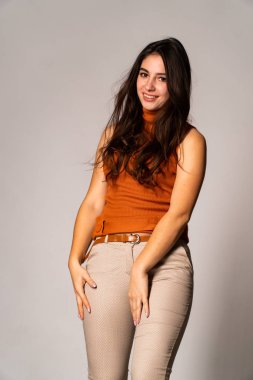 Güzel esmer model, karanlık odada poz veriyor. 